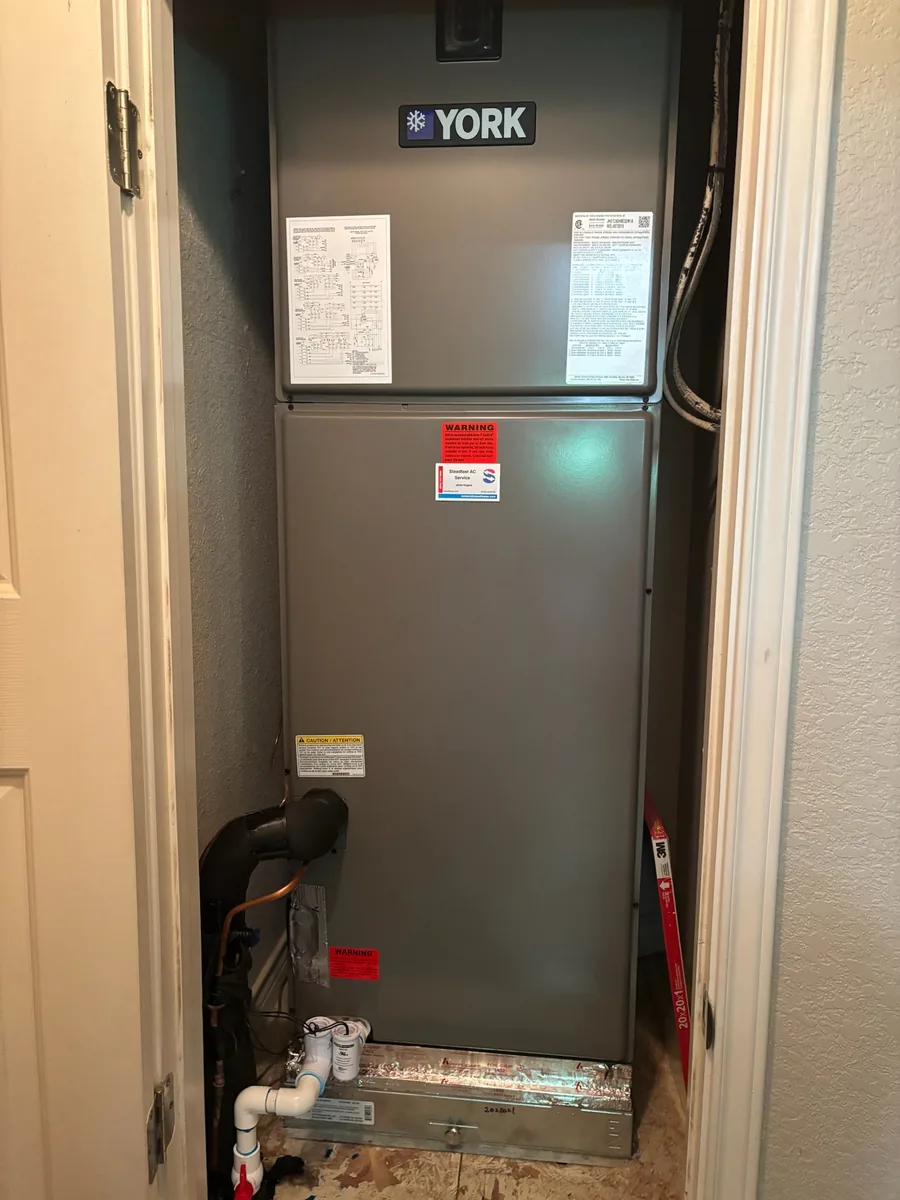 A YORK air handler in a closet carrying Steadfast's own service sticker